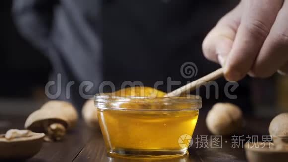 厨师蘸木蜂蜜，用液体蜂蜜粘在玻璃碗上，用蜂蜜烹饪，用天然蜂蜜做甜食