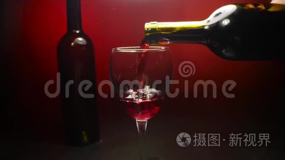 在红色背景下慢慢倒入酒杯的红酒