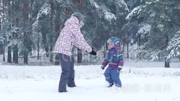 一位快乐的母亲抱着她的儿子，在一个美丽的冬日里，在森林或公园里亲吻他