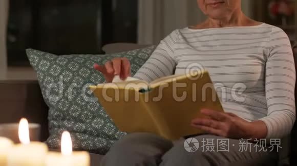 快乐的老年妇女晚上在家看书