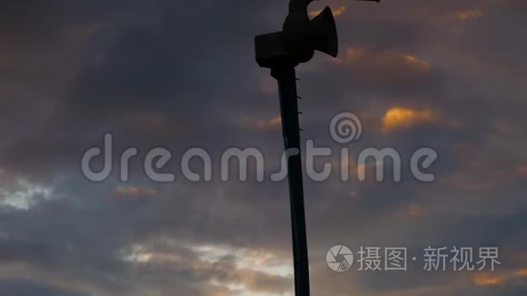 旧的机械民防警报器的剪影，也被称为空袭警报或龙卷风警报对多云的日落天空。