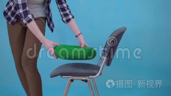 女人坐在矫形枕头上的椅子上的蓝色背景，痔疮的概念接近