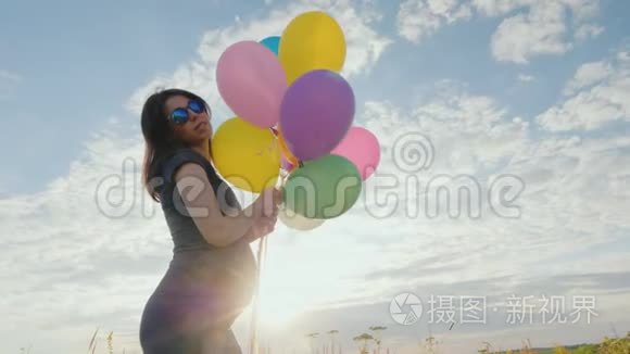 年轻的孕妇无忧无虑地玩气球