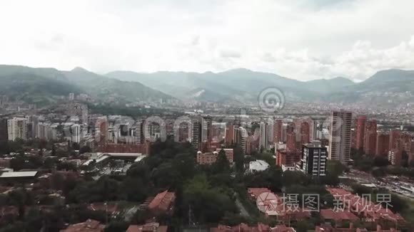向后飞行的无人机在哥伦比亚麦德林市的鸟瞰图，显示了城市景观和地区