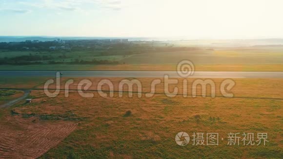 从空中俯瞰田野之间的道路。 夏天的颜色。 绿色乡村和汽车的空中行驶。 4K.