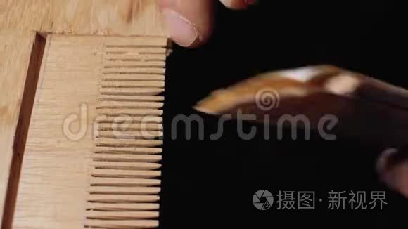 一个木工师傅用砂纸把木梳手工磨碎. 4千克