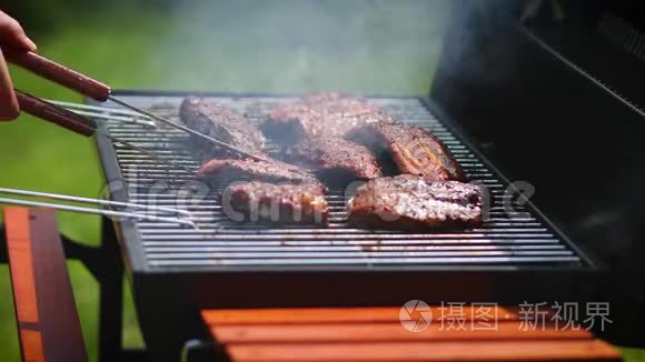 他在花园里的煤烤架上烤排骨视频