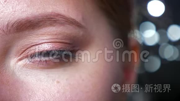 美丽的白种人女人用亲切的目光直视镜头的绿色眼睛上的特写眼影