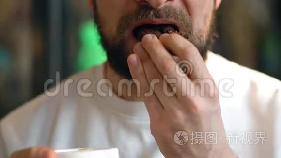 男人在咖啡馆里吃巧克力饼干和喝咖啡