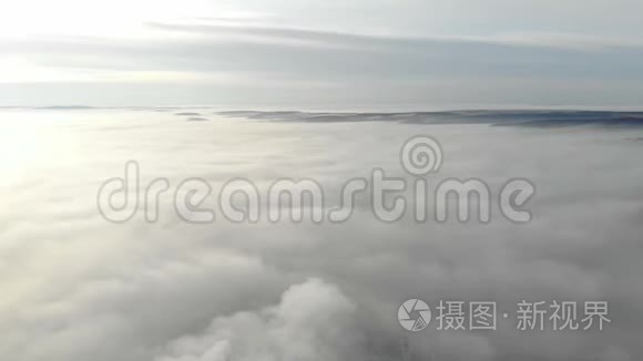 浓雾笼罩着城市。 摄像机向上移动，打开了一个笼罩在城市上空的雾的全景。