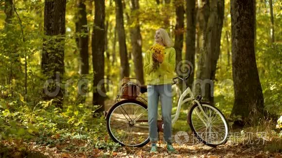 滑稽的表情和疯狂的人。 秋天快乐的女孩和快乐。 无忧无虑的女人。 带着花的复古自行车的秋女