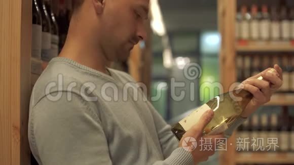 有魅力的家伙仔细检查了白酒商店一个白酒瓶标签上的成分。 酒瓶是