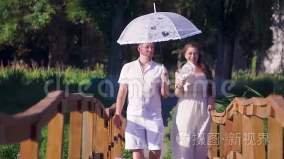 恋爱中的男女手拿雨伞走在桥上视频