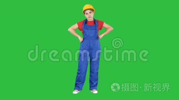 愤怒的女性建筑工人在绿色屏幕上显示出拳头的负面攻击性情绪，Chroma键。