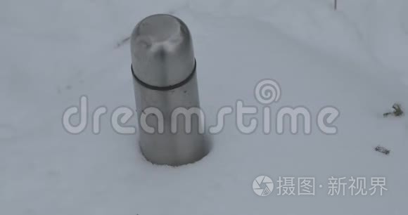 铝热水瓶粘在雪地里视频