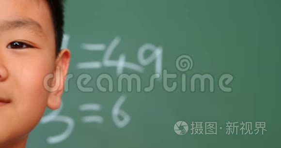 4k学校教室里，亚洲小学生靠黑板站着