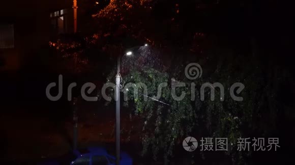 一盏灯在雨夜的城市里闪烁。 电力问题。 恐怖之夜。 雨夜闪烁的路灯.. 看法