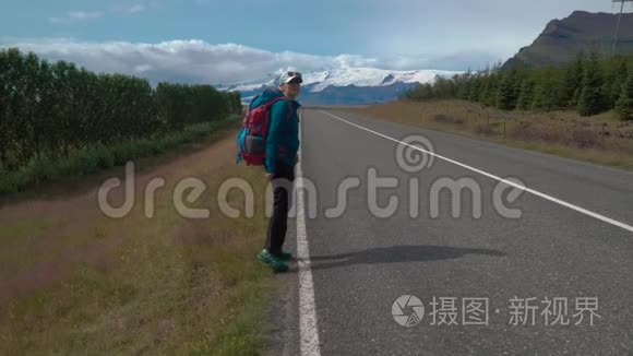 带背包的女旅行者在柏油路上视频