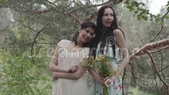 两个穿着短裙的漂亮女孩站在岩石上，开着野花，看着森林