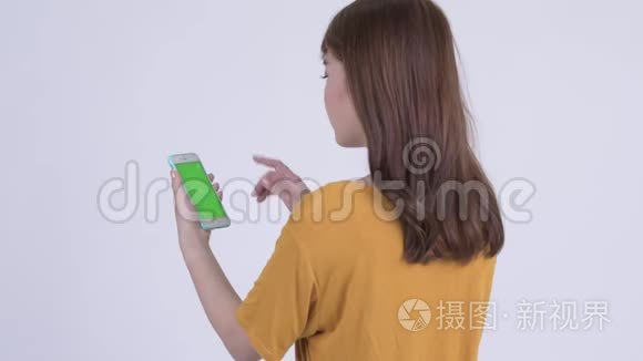 用电话欣赏快乐年轻的亚洲女人的后景