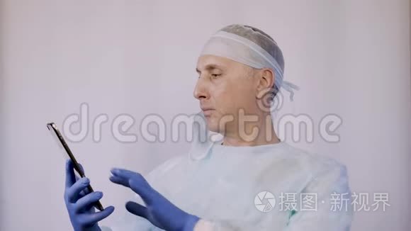 医生在平板电脑上看病人的x光片。 他正在准备手术。