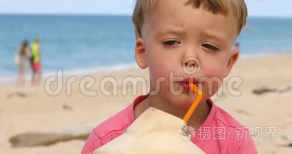 可爱的儿童在海滩上喝椰子水视频