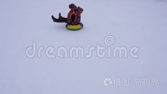 人在雪碟上滑下雪山，笑了.. 冬天雪橇上的圣诞节假期