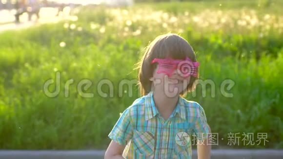 特写照片，快乐的小可爱男孩在公园玩肥皂泡。 夏天在外面跳舞的孩子