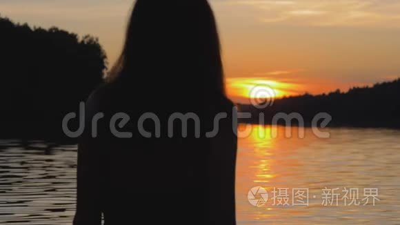 夕阳西下的幸福女人举起双臂转身