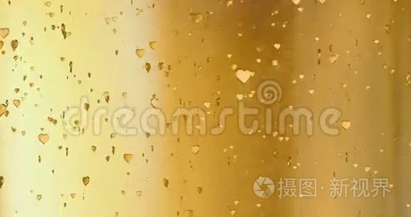 情人节金色的心形起来就像金色背景下的细碎香槟泡沫运动，节日的情人节