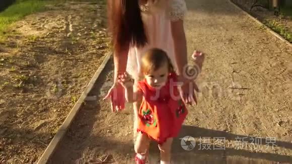 妈妈抓住了在公园里学会走路和微笑的小宝宝。 慢动作