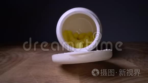 黄色药丸或胶囊旁边的瓶子在木桌背景。 药品处方，治疗用药.. 制药