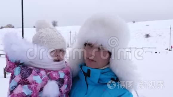 在寒冷的冬天，我妈妈手里的宝贝在白雪上散步。 母亲带着孩子在大自然中散步。 圣诞节