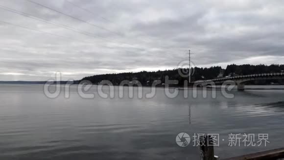 灰色暴风雨的日子，带着海湾的水和带着汽车的道路