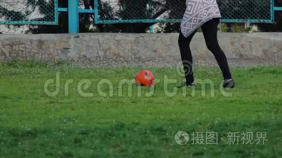 面目全非的女孩在体育场踢球。 年轻女子训练足球。 把注意力集中在腿上