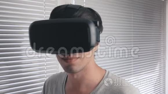 年轻人用他的VR耳机在办公室背景下观看360视频。 快关门。