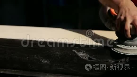 一个专业的机械师在油漆前把车身磨碎。