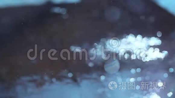 拍摄开始是雨滴的模糊，最后是水闪发光的水坑