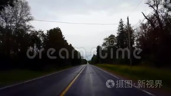 在白天驾驶农村潮湿的道路俯瞰多云的天空。 雨水暗雨后的POV驾驶点