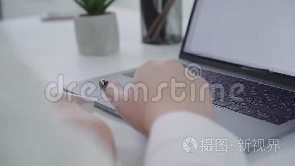 一只女性手在键盘上打字并翻动笔记本电脑。 秘书或女商人的手