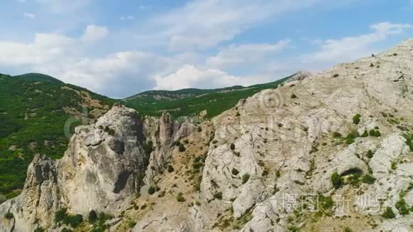 以绿色山谷和天空为背景的岩层的顶部视图。 中枪。 风景如画的山景