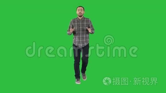 英俊的西班牙男子模型与相机交谈，并在绿色屏幕上行走，Chroma键。