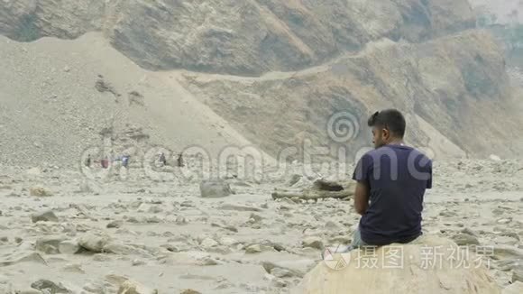 尼泊尔导游在石头上休息。 玛纳斯鲁巡回跋涉。
