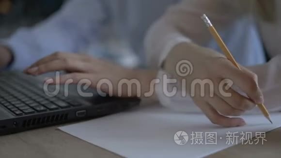 女人在笔记本电脑键盘上打字，在办公室里写字。 合上手提电脑键盘上的女人手