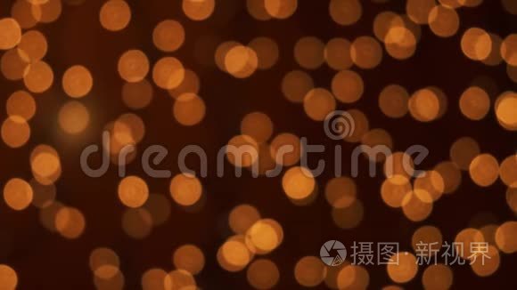 橙色的圣诞照明在离焦。 模糊的抽象粒子背景