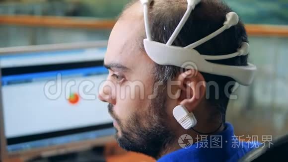 一个工程师头上戴着特殊的脑电波扫描传感器，后视图。