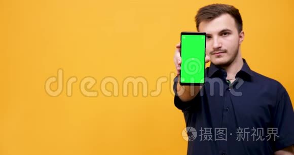 年轻人手里拿着绿色屏幕的手机