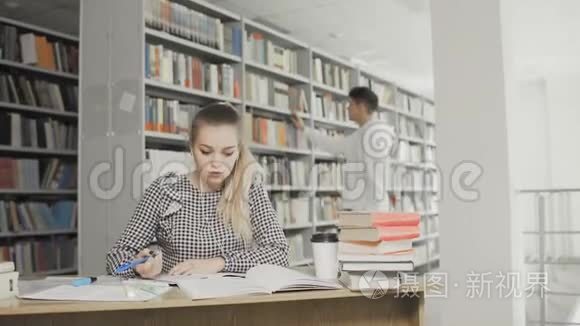 两名白种人大学生准备在图书馆考试