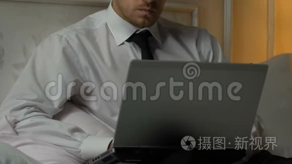 一个人在笔记本电脑上打周报，一个忙碌的记者在床上写文章