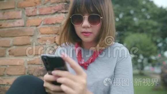 旅游亚洲妇女使用智能手机检查社交媒体，同时放松后，在阿育塔亚旅游泰国